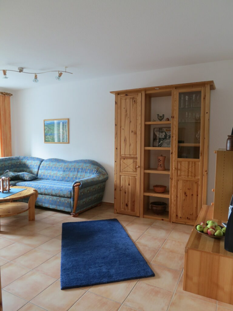Der Wohnraum mit Schlafsofa ist u. a. mit mit einer gemülichen Sitzecke, einem großen Flachbildfernseher, einem DVD-Player und einer kleinen Musikanlage ausgestattet. Der Süd-Balkon kann von dem Wohnzimmer betreten werden.